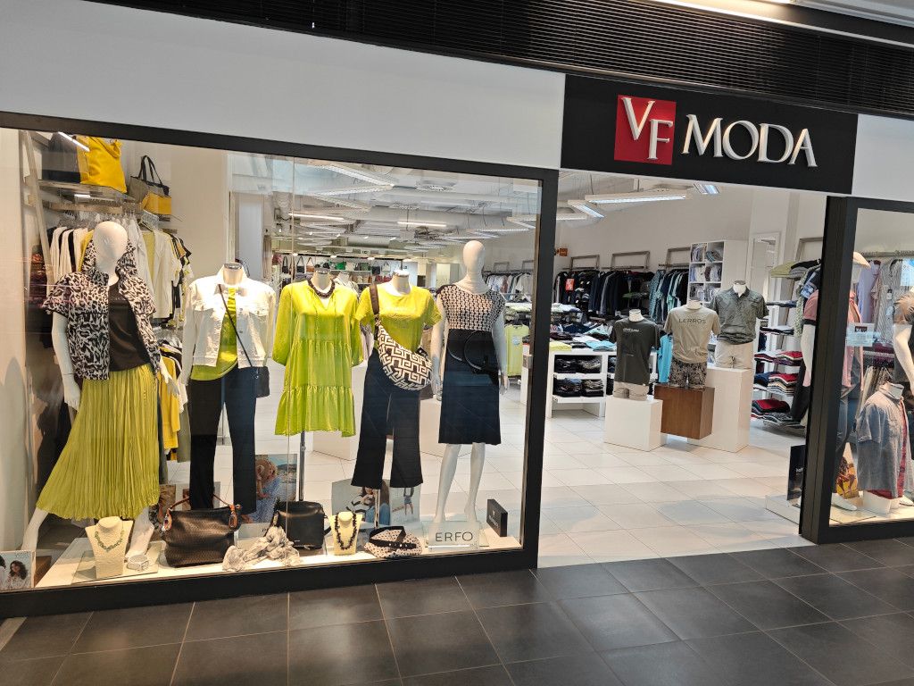 Černo zelená kolekce ve výloze módního butiku VF MODA. Šaty, trička, volné široké kalhoty, bílá džíska a nebo černo-bílý zvířecí vzor na krátké bundičce do pasu. Pánské modely jsou v duchu přírodních tónů béžové a olivové. Trička, póla a strečové šortky nebo bermudy.